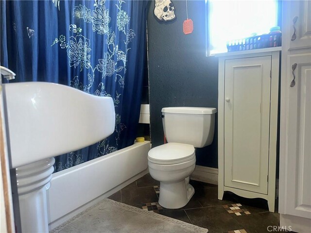 bathroom featuring tile patterned flooring, shower / tub combo, and toilet