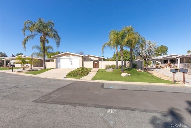 view of front of house featuring concrete driveway, an attached garage, a front yard, fence, and a residential view