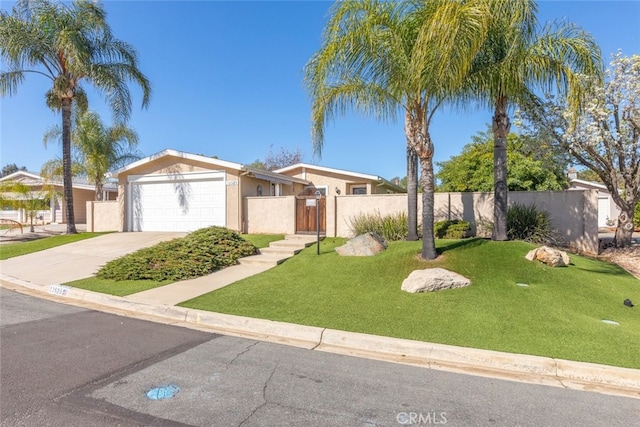 mid-century modern home featuring a garage, fence, concrete driveway, stucco siding, and a front lawn