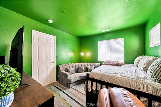 bedroom with wood finished floors and visible vents