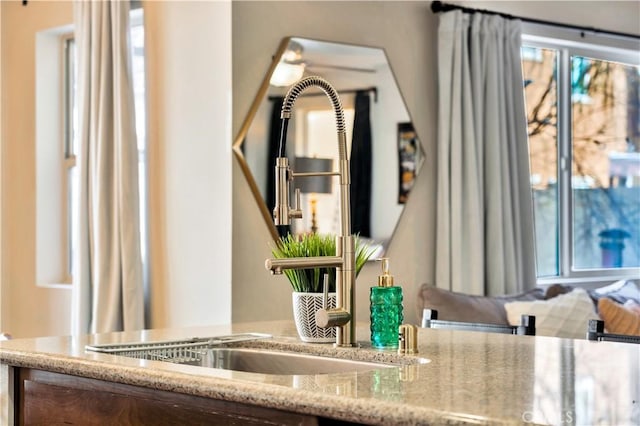 room details with a sink and light stone countertops