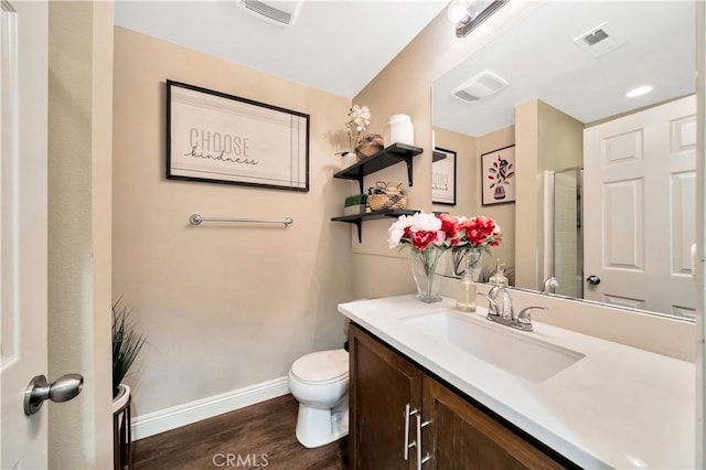 bathroom with vanity, wood finished floors, baseboards, and visible vents