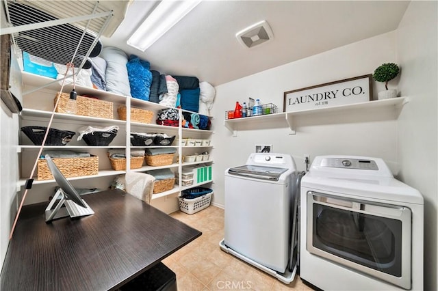 laundry room with light tile patterned floors, washing machine and dryer, and laundry area