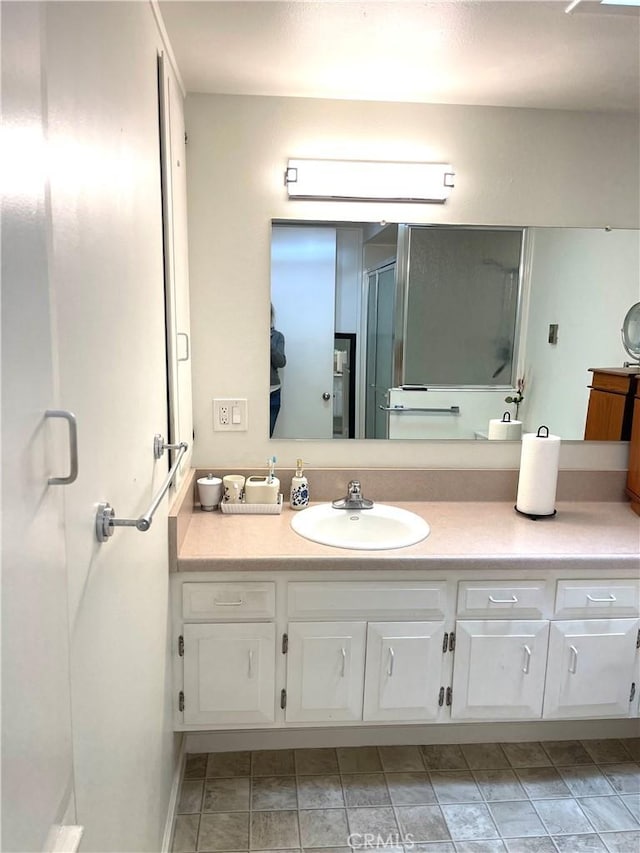 bathroom with a shower stall and vanity