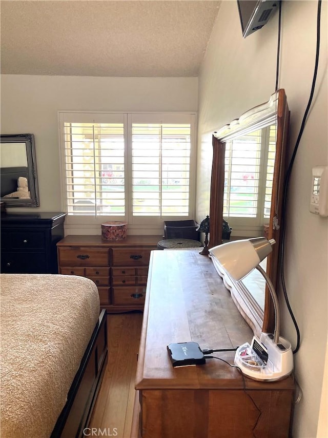 bedroom featuring a textured ceiling and wood finished floors