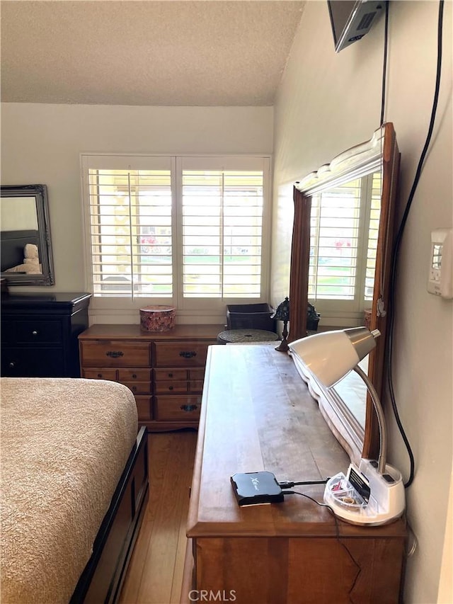 bedroom with wood finished floors and a textured ceiling