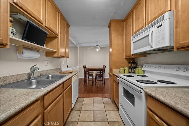 kitchen featuring brown cabinets, light tile patterned floors, a sink, ceiling fan, and white appliances