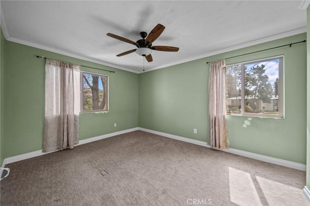 empty room with carpet floors, a ceiling fan, baseboards, and crown molding