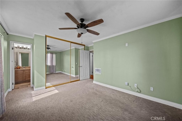 unfurnished bedroom with carpet, visible vents, crown molding, and baseboards