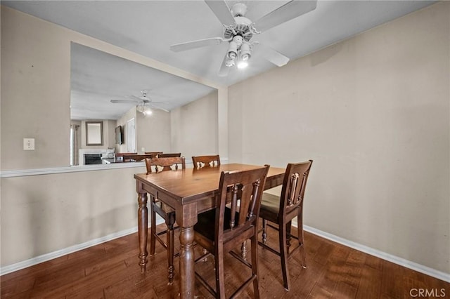 dining area with ceiling fan, baseboards, and wood finished floors