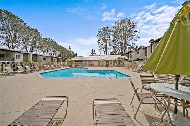 community pool featuring fence and a patio