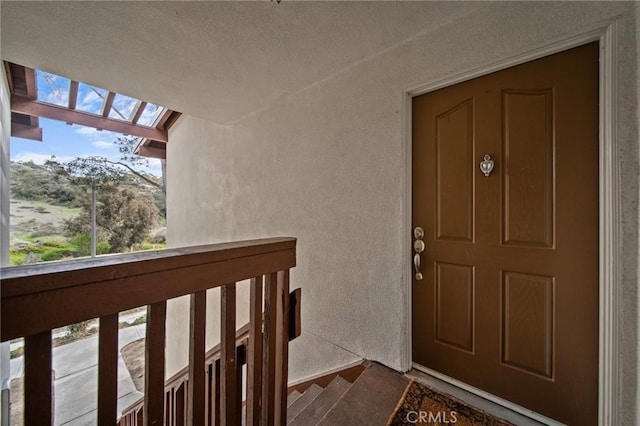 doorway to property featuring a balcony and stucco siding