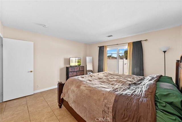 bedroom featuring access to exterior, light tile patterned flooring, visible vents, and baseboards