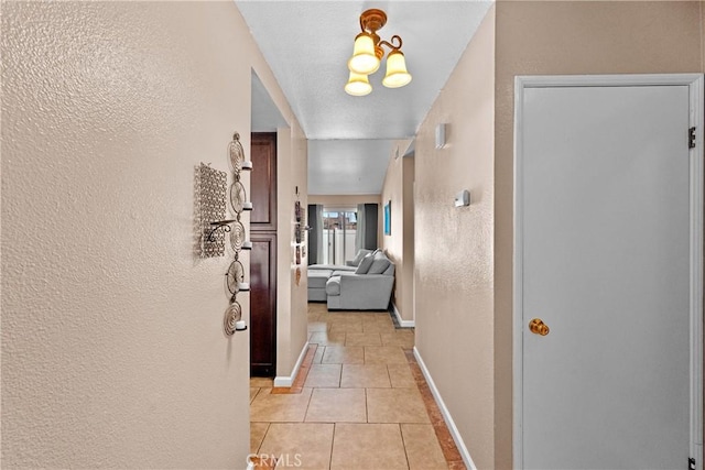 44680 La Paz Rd, Temecula, CA 92592 - corridor with light tile patterned flooring, a textured wall, and baseboards