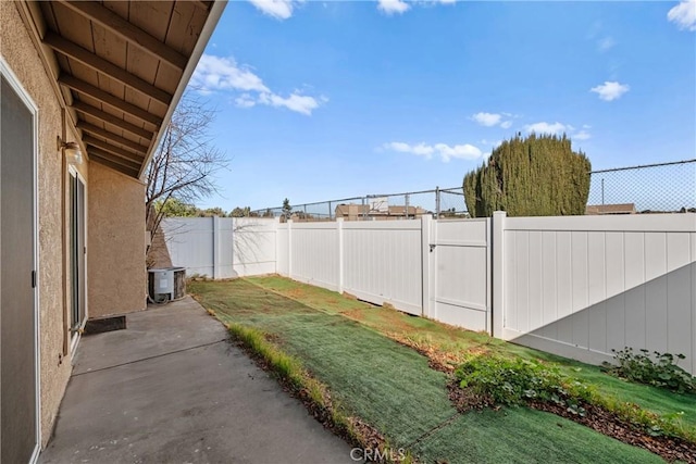 view of yard featuring a patio area, a fenced backyard, and central AC