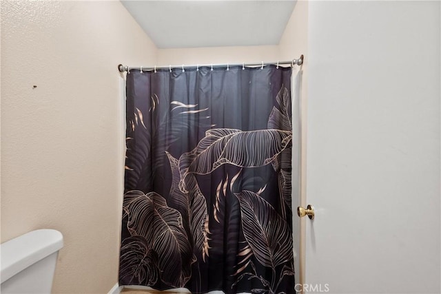 full bath featuring a shower with curtain and toilet