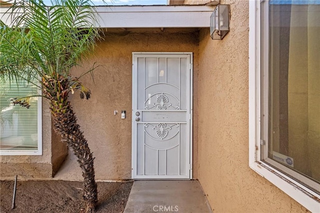 property entrance with stucco siding