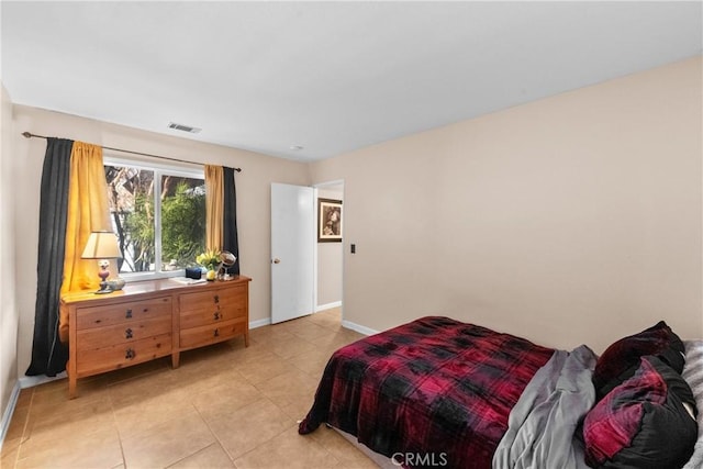 bedroom with light tile patterned floors, visible vents, and baseboards