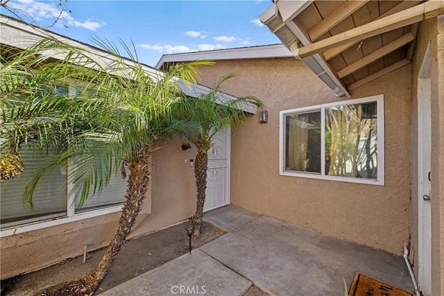 property entrance with a patio area and stucco siding