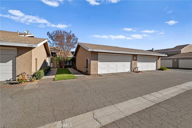 view of property exterior with stucco siding and community garages