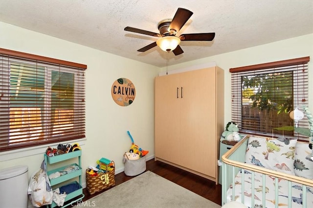 interior space featuring dark wood-style floors, a textured ceiling, and a ceiling fan