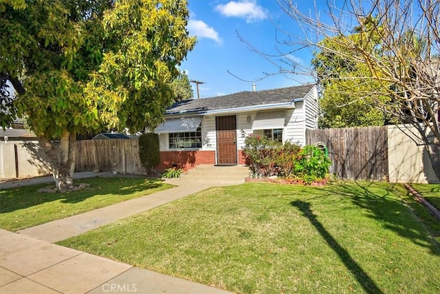 bungalow-style home with fence, a front lawn, and brick siding