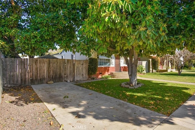 obstructed view of property with brick siding, fence, and a front lawn