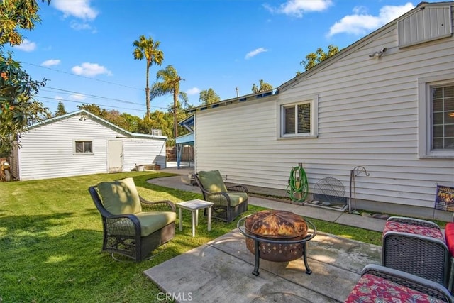 exterior space with an outdoor fire pit, an outbuilding, and a patio