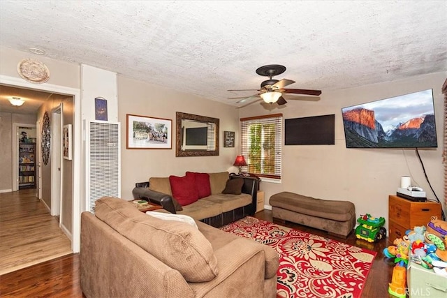 living room featuring a textured ceiling, a ceiling fan, and wood finished floors