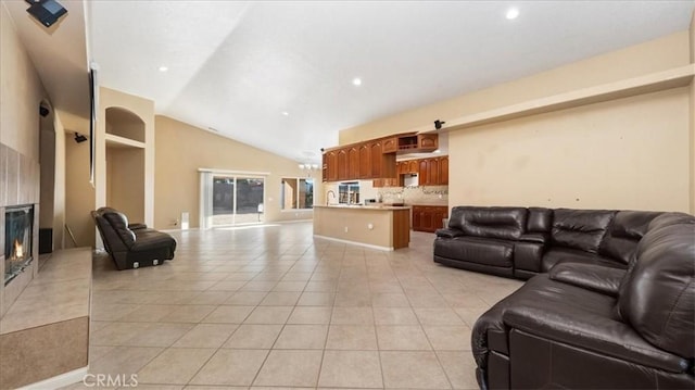 living area featuring recessed lighting, a fireplace, vaulted ceiling, and light tile patterned flooring