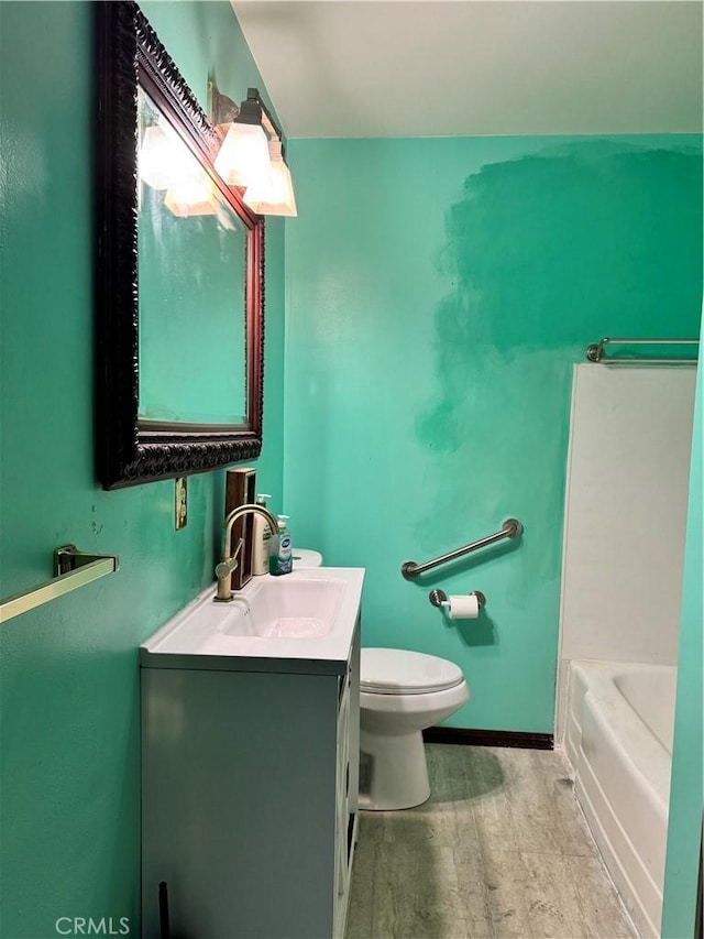 bathroom featuring a tub to relax in, toilet, vanity, baseboards, and a shower