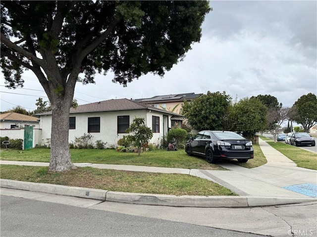 view of front of home with a front lawn and stucco siding