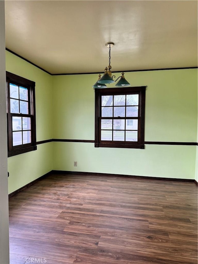 unfurnished room with wood finished floors and baseboards