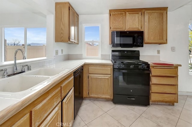 kitchen with black appliances, light countertops, and a healthy amount of sunlight