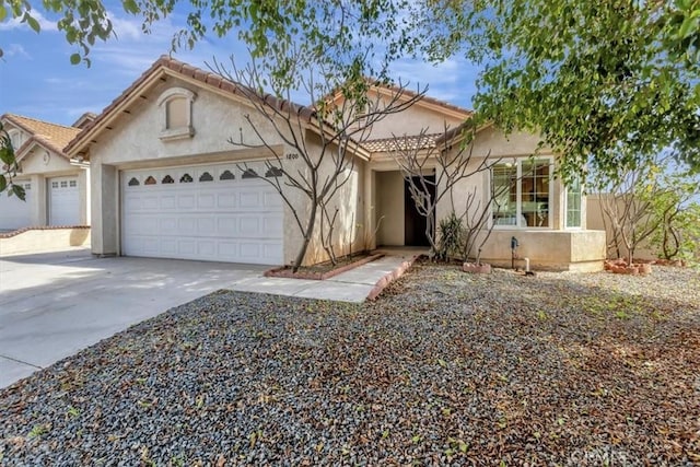 view of front of property with a garage, concrete driveway, and stucco siding