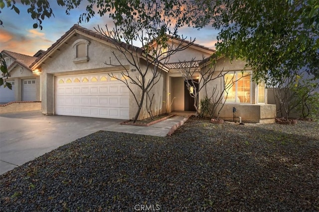 view of front of property featuring a garage, driveway, and stucco siding