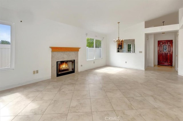 unfurnished living room with light tile patterned floors, baseboards, an inviting chandelier, lofted ceiling, and a tile fireplace