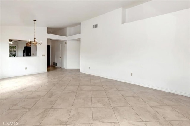 unfurnished living room with visible vents, an inviting chandelier, baseboards, and lofted ceiling