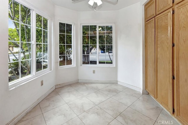 unfurnished sunroom with ceiling fan