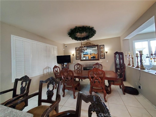 dining room featuring tile patterned floors and a glass covered fireplace