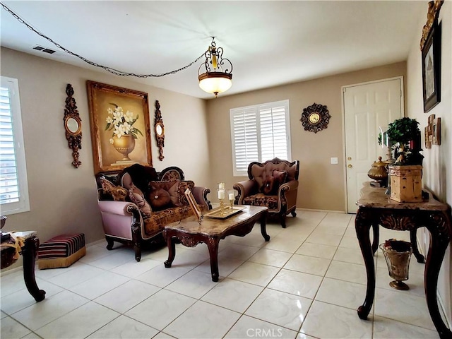 living area with a wealth of natural light, visible vents, and light tile patterned floors