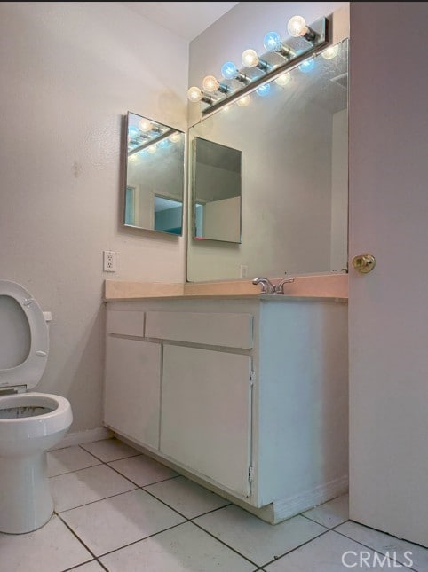 bathroom with toilet, tile patterned floors, and vanity