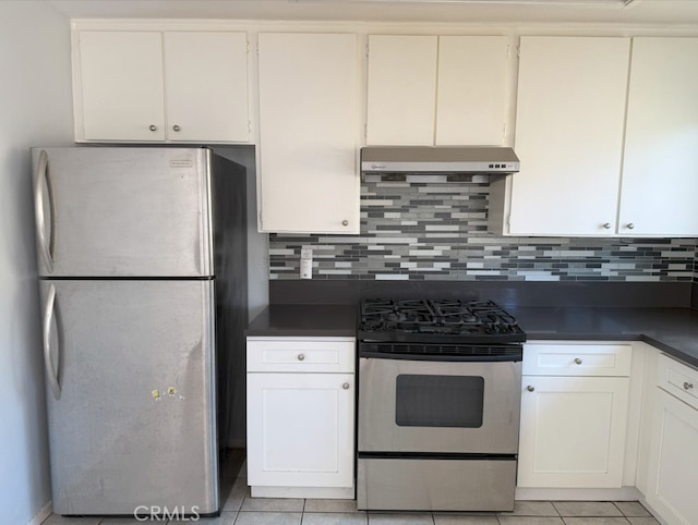 kitchen with dark countertops, under cabinet range hood, tasteful backsplash, and appliances with stainless steel finishes