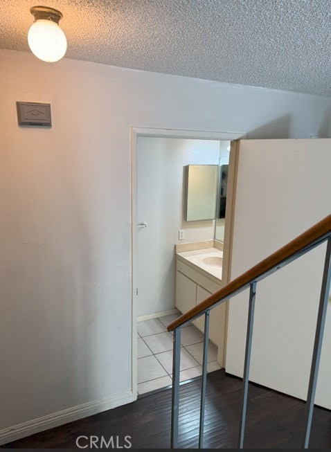 interior space featuring a textured ceiling, baseboards, and wood finished floors