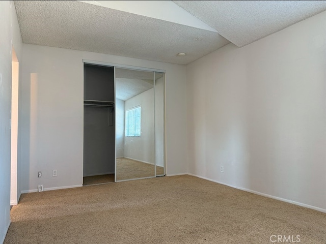 unfurnished bedroom featuring carpet floors, a closet, a textured ceiling, and baseboards