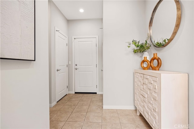 hall with baseboards and light tile patterned floors