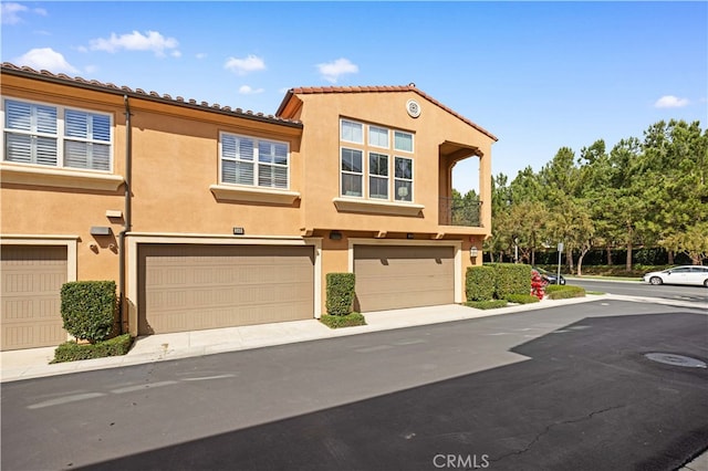 townhome / multi-family property featuring an attached garage and stucco siding