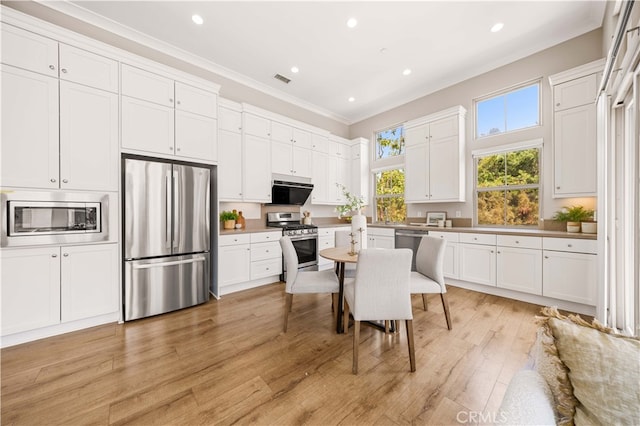 kitchen featuring stainless steel appliances, recessed lighting, ornamental molding, white cabinetry, and light wood-type flooring