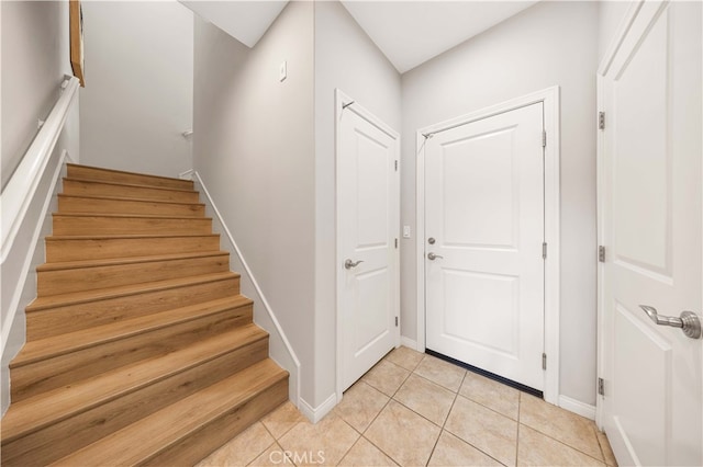 staircase featuring baseboards and tile patterned floors