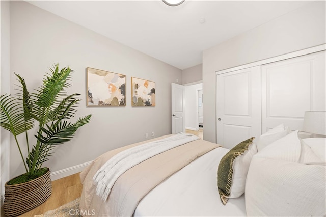 bedroom featuring a closet, baseboards, and wood finished floors